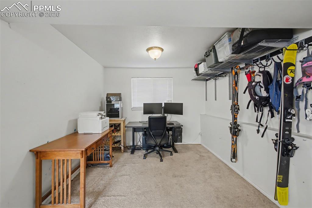Image 21 of 37: L shaped family room used as office and sporting storage