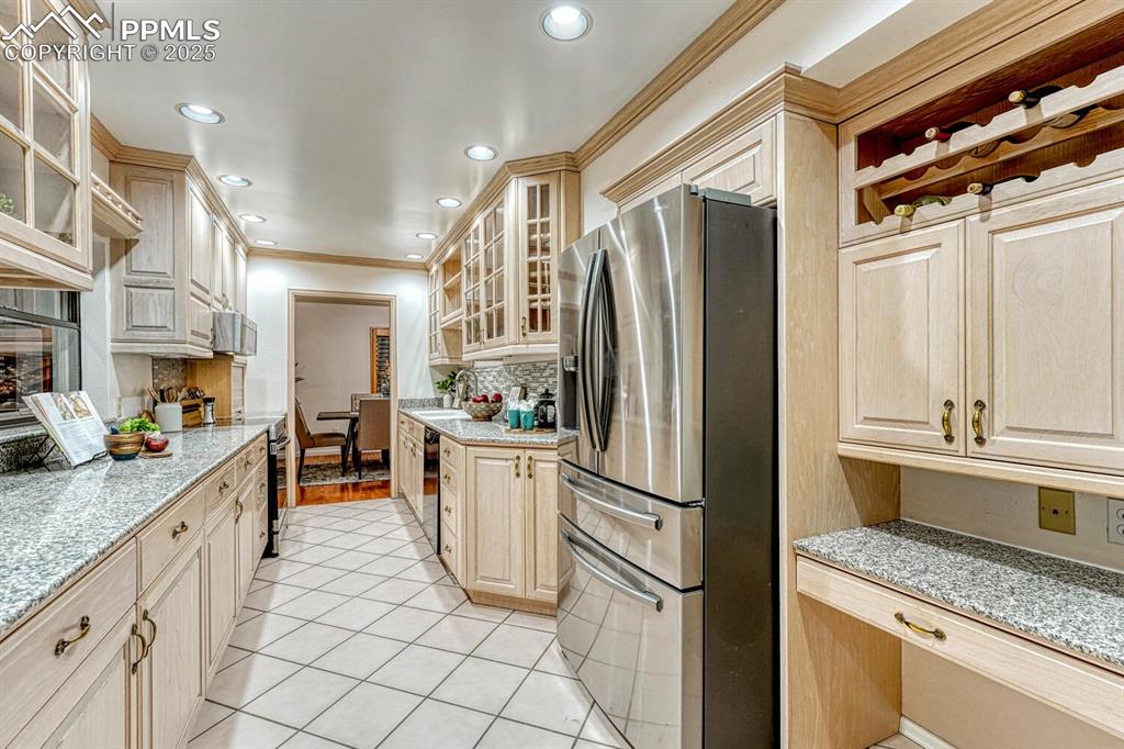 Image 15 of 50: The beautifully updated Kitchen offers a tile floor, planning desk, abundan