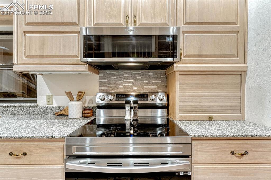 Image 16 of 50: Smooth top stainless steel range oven and built-in microwave oven in the Ki