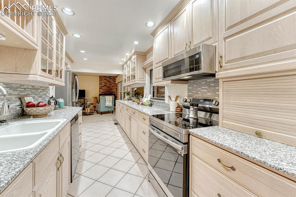 Image 17 of 50: Attractive wood cabinets, some with glass fronts, granite countertops, and 