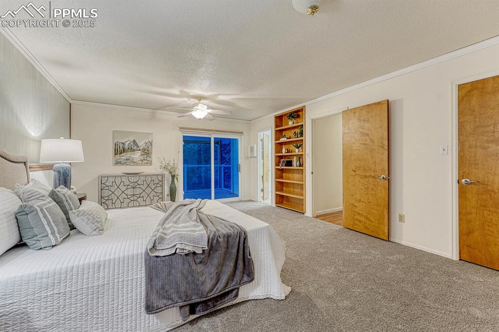 Image 34 of 50: The upper level Primary Bedroom has a slider to a private, enclosed balcony