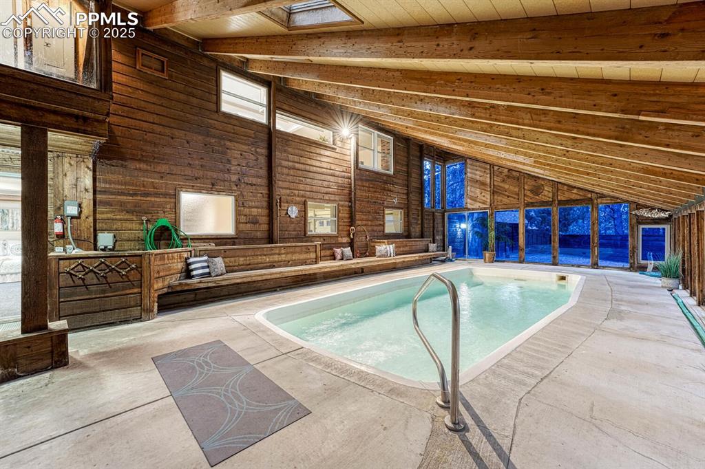Image 42 of 50: Indoor pool and hot tub room with built in seating.