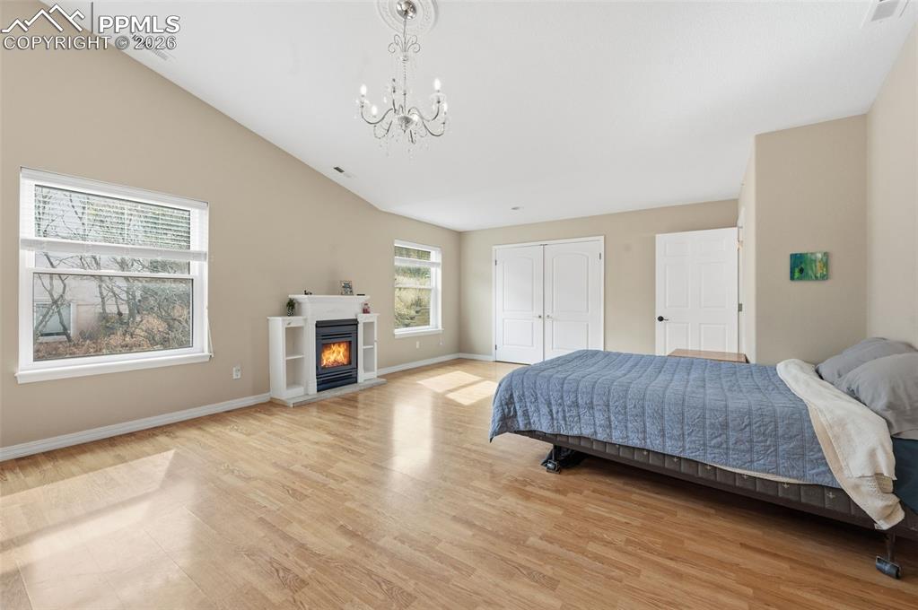Image 19 of 50: Primary bedroom with a gas fireplace, large walk in cedar lined closet, and