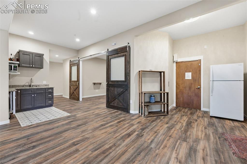 Image 31 of 50: Kitchenette or wetbar off the family room. The door to the elevator is on t