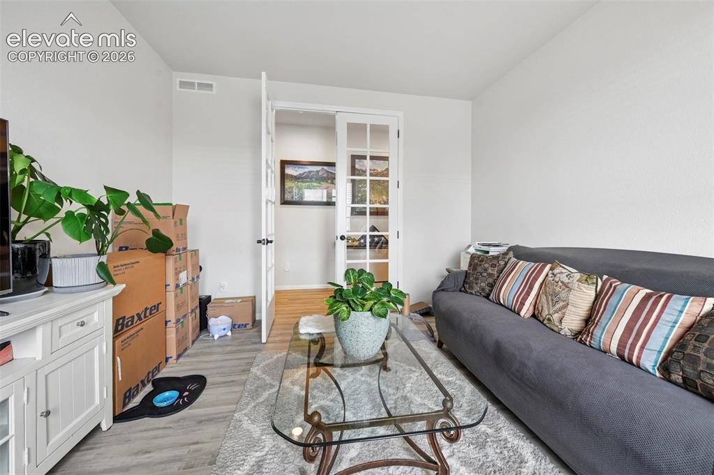 Image 11 of 31: Wood-finish flooring, white walls, and French doors