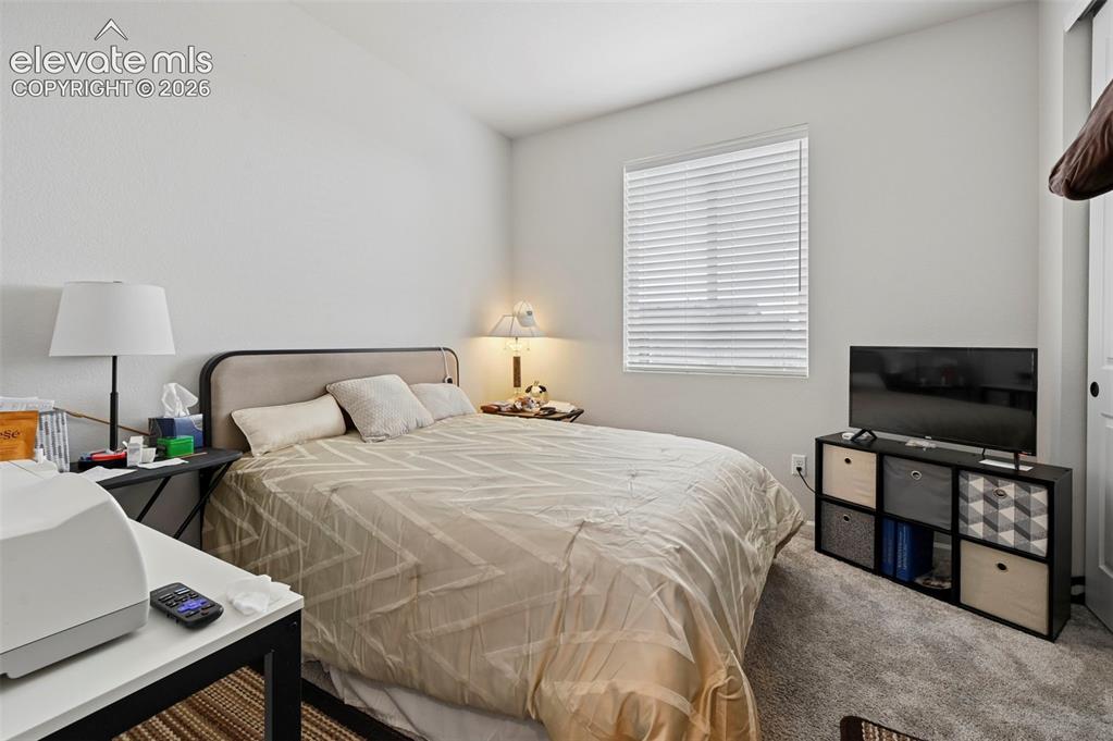 Image 17 of 31: Neutral wall color with textured finish, window with blinds, and carpeted f