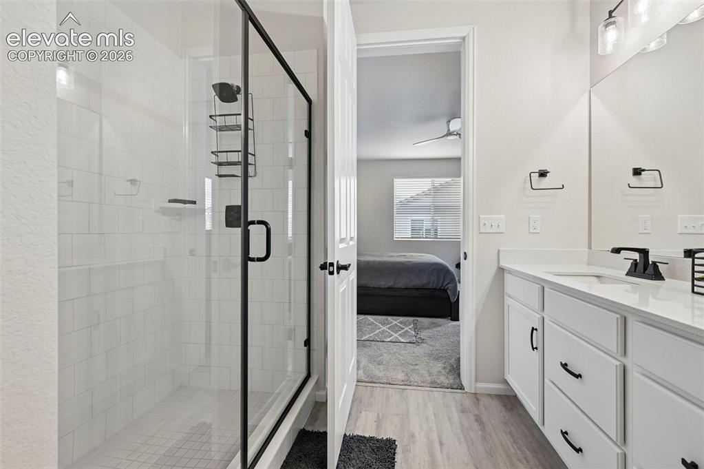 Image 19 of 31: Walk-in shower with clear glass enclosure and black frame, white tiled show