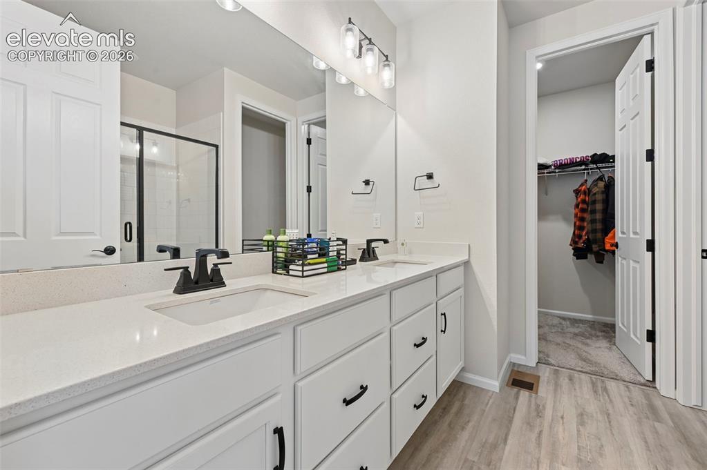 Image 20 of 31: Dual vanity with white cabinetry and integrated sinks, quartz-finish counte
