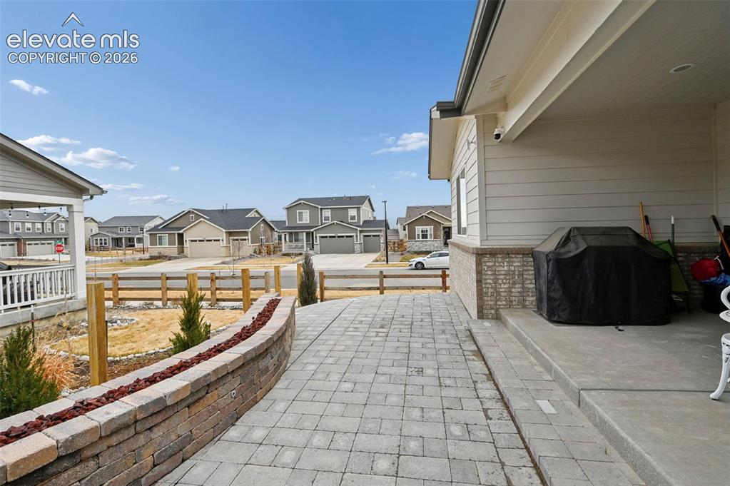 Image 25 of 31: Paver stone walkway leading to a concrete porch, featuring a stone retainin