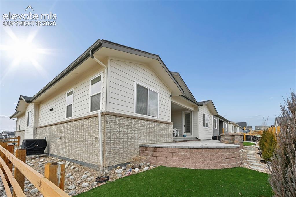 Image 27 of 31: Exterior featuring horizontal siding, brick-patterned foundation, and a cov