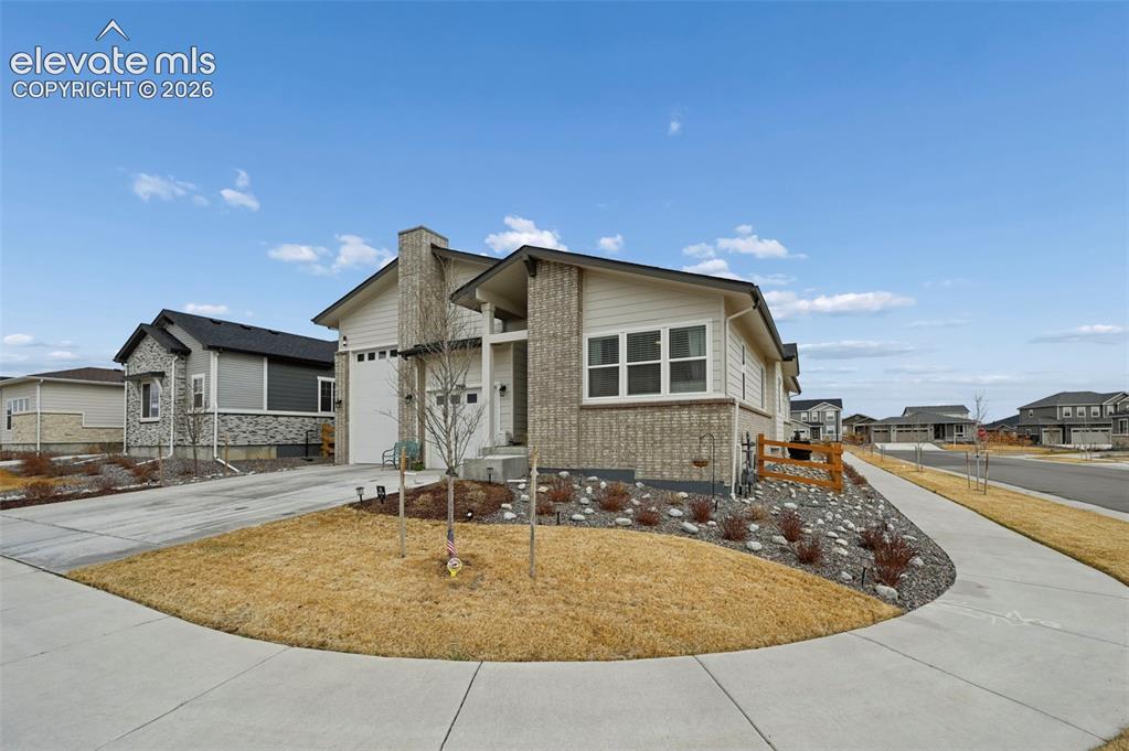 Image 28 of 31: Contemporary exterior featuring a stone and siding facade, a two-car garage