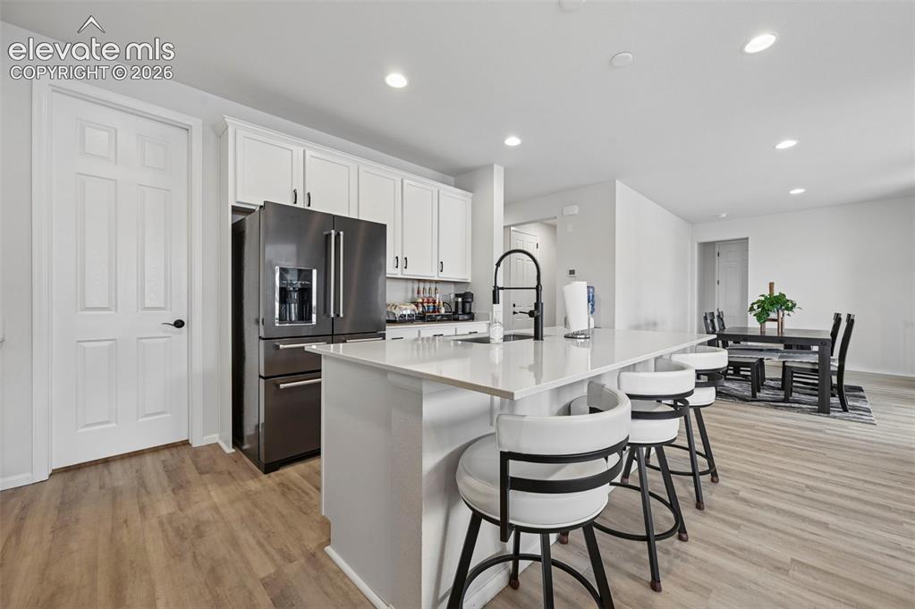 Image 3 of 31: Kitchen featuring white shaker cabinetry, an integrated stainless steel ref