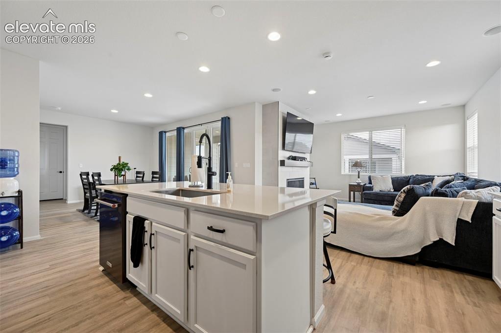 Image 4 of 31: Open-concept living area featuring wood-finish flooring, recessed lighting,