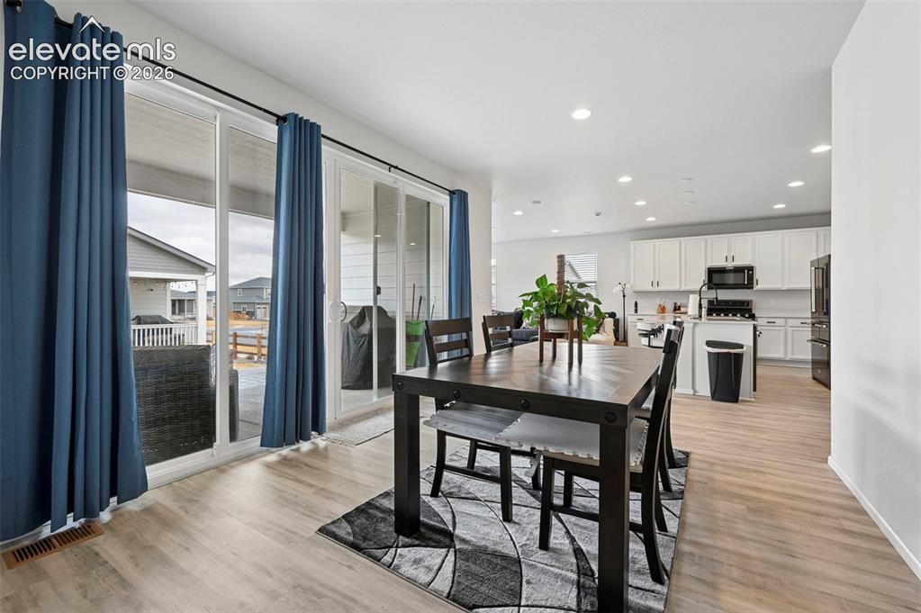 Image 7 of 31: Light wood-finish flooring throughout, multiple recessed lights, sliding gl