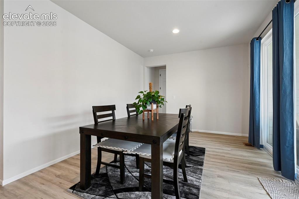 Image 8 of 31: Recessed lighting, wood-finish flooring, and white walls