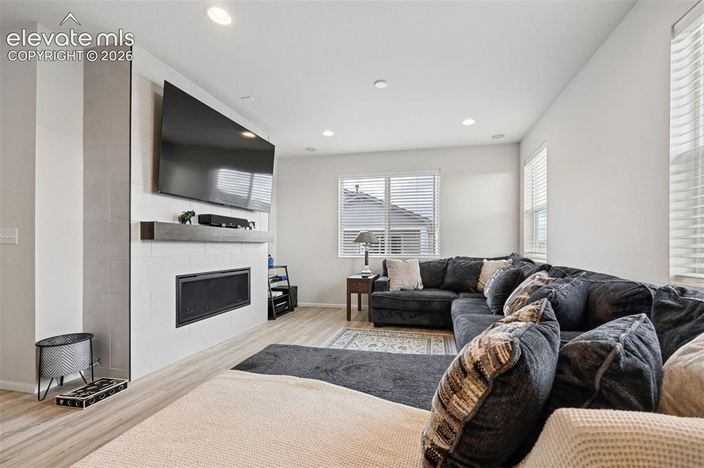 Image 9 of 31: Living area with wood-finish flooring, recessed lighting, and white walls