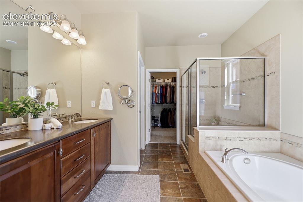 Image 20 of 48: Primary bath includes a double vanity and beautiful spa shower and tub! 