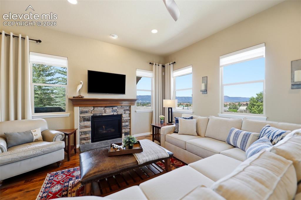Image 6 of 48: The living room has a gas fireplace, accented with beautiful stonework and 