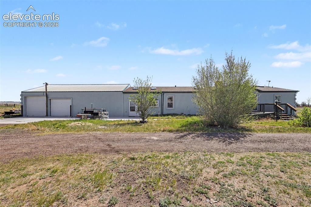 Caption: Exterior property featuring a detached garage structure with two overhead doors, a metal roof, and a