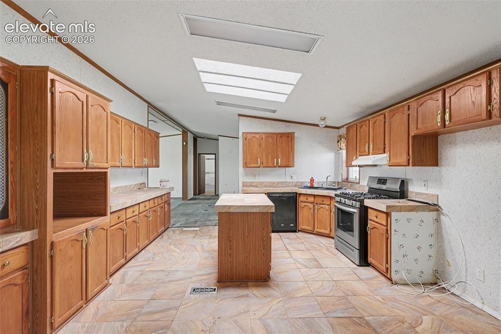Image 11 of 26: Spacious kitchen featuring extensive wood cabinetry, an integrated kitchen 