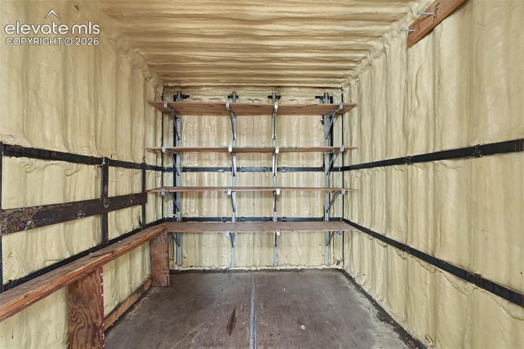 Image 21 of 26: Insulated interior space featuring multiple levels of built-in shelving, a 
