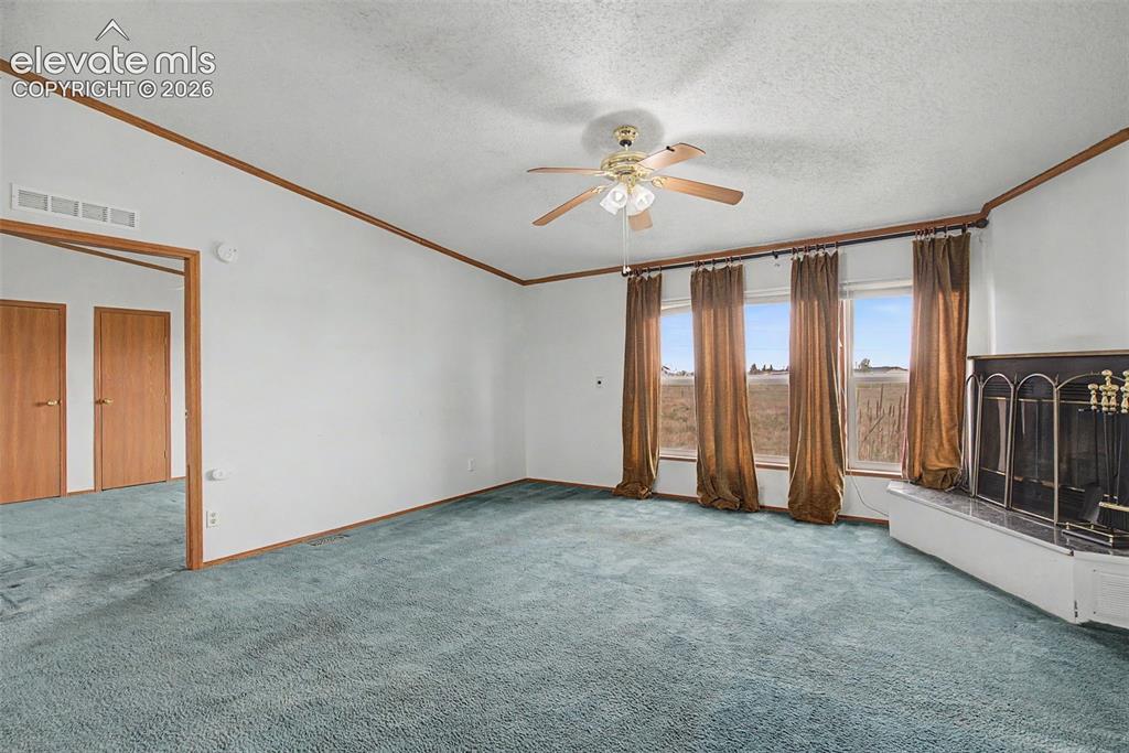Image 5 of 26: Spacious interior room featuring a vaulted ceiling and ceiling fan