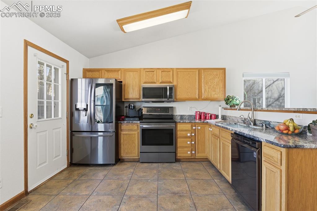 Image 8 of 32: Huge kitchen with ceramic tile floors, granite counters, and black stainles