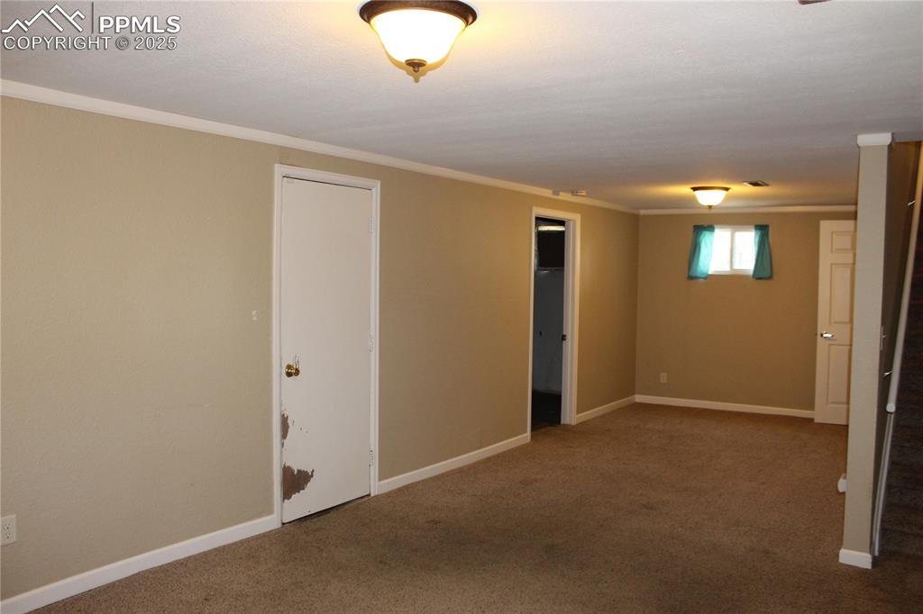 Image 10 of 19: 2012 Basement with carpet floors and crown molding; door to garage