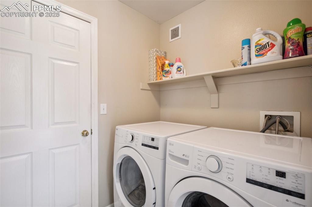 Image 11 of 28: Washroom featuring washing machine and clothes dryer