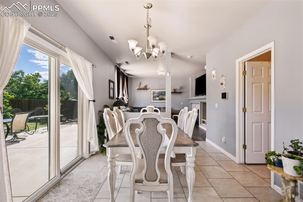 Image 15 of 28: Dining space featuring a chandelier and light tile patterned floors
