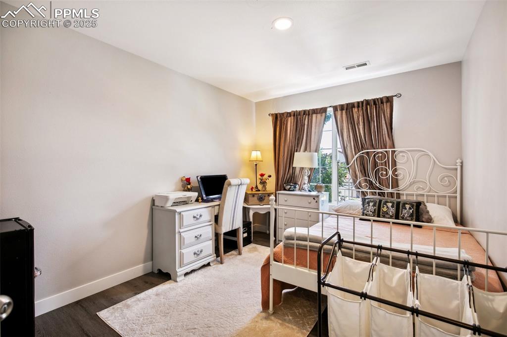 Image 18 of 28: Bedroom with wood finished floors and recessed lighting