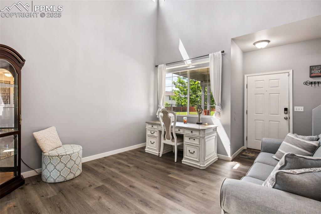 Image 5 of 28: Office featuring dark wood finished floors, a high ceiling, and built in st