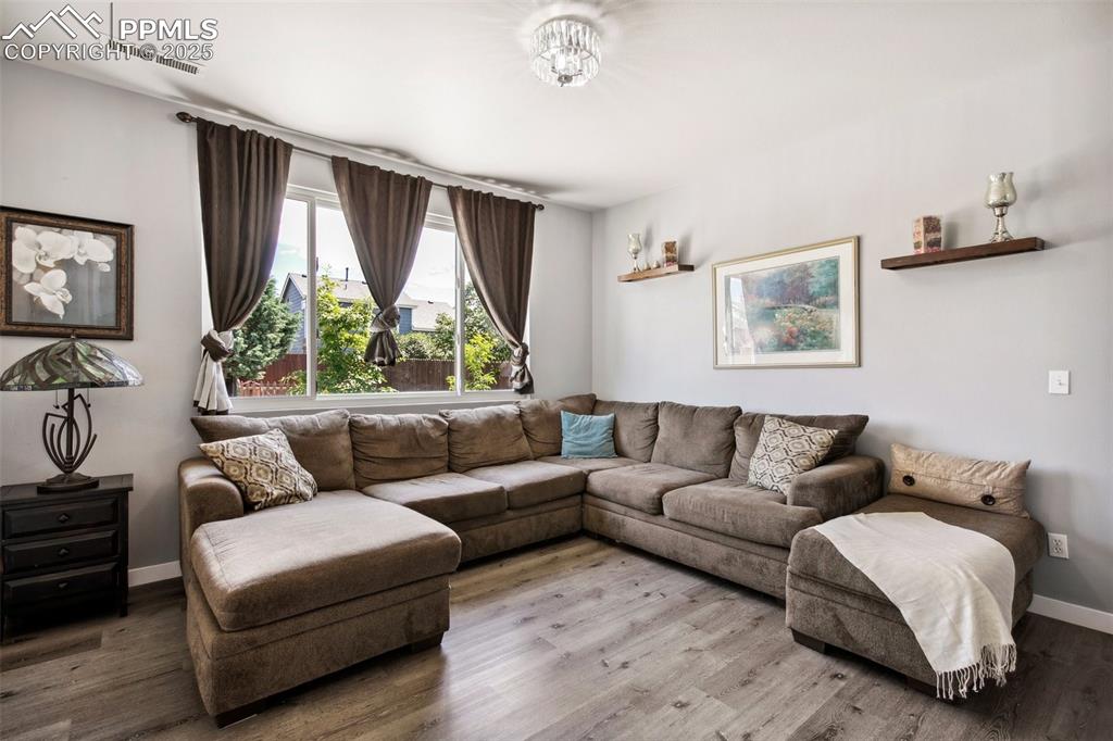 Image 9 of 28: Living room with wood finished floors and baseboards