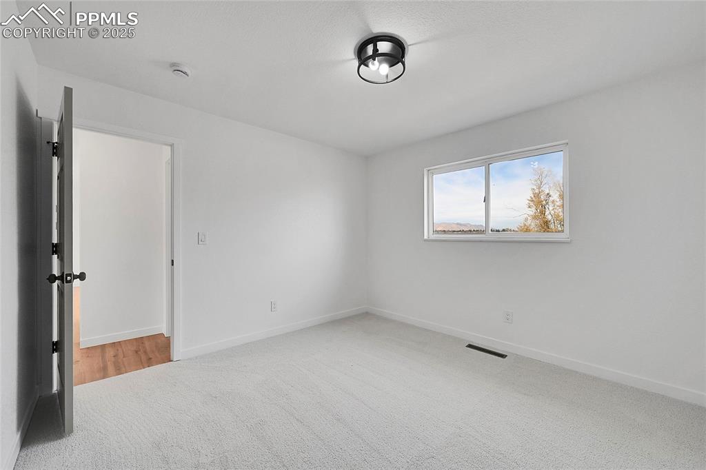 Image 11 of 29: Unfurnished room featuring light carpet and baseboards