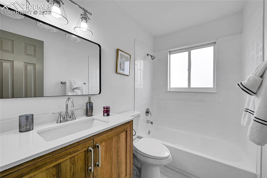 Image 13 of 29: Full bath featuring shower / washtub combination, vanity, and a textured wa
