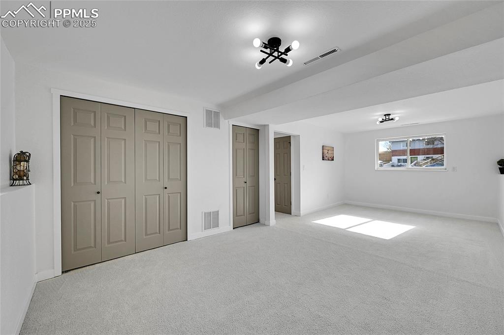Image 18 of 29: Unfurnished bedroom featuring carpet flooring and multiple closets
