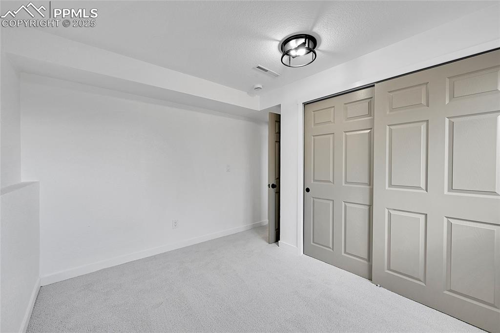 Image 20 of 29: Unfurnished bedroom with carpet floors, a closet, and a textured ceiling