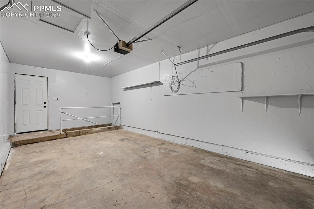 Image 23 of 29: Garage featuring a garage door opener