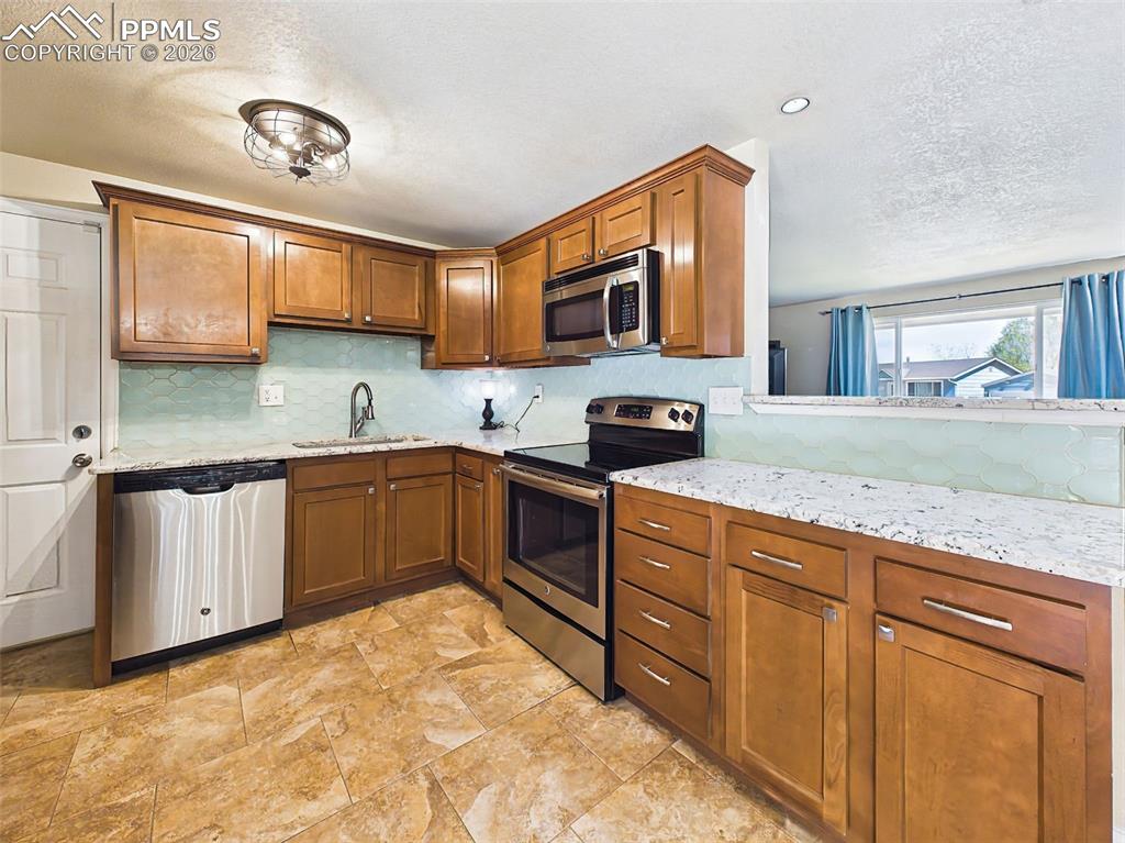 Image 11 of 50: Beautiful granite countertops and stainless steel appliances complement the
