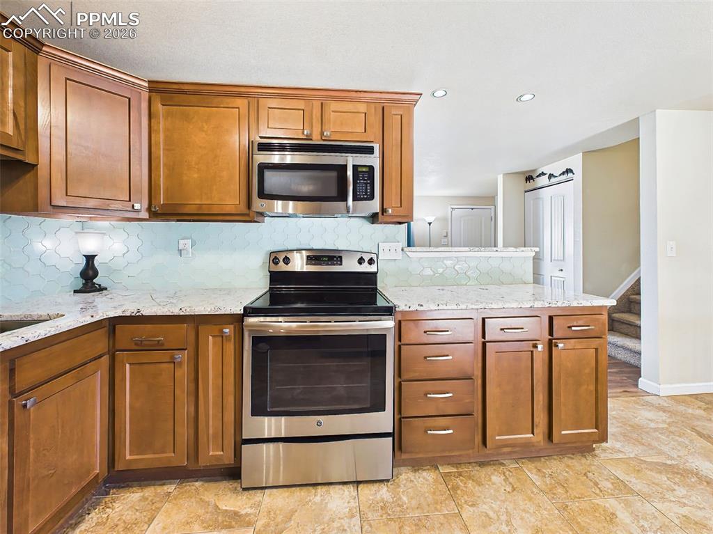 Image 12 of 50: Functional cooking space with ample cabinetry, updated appliances, and a co