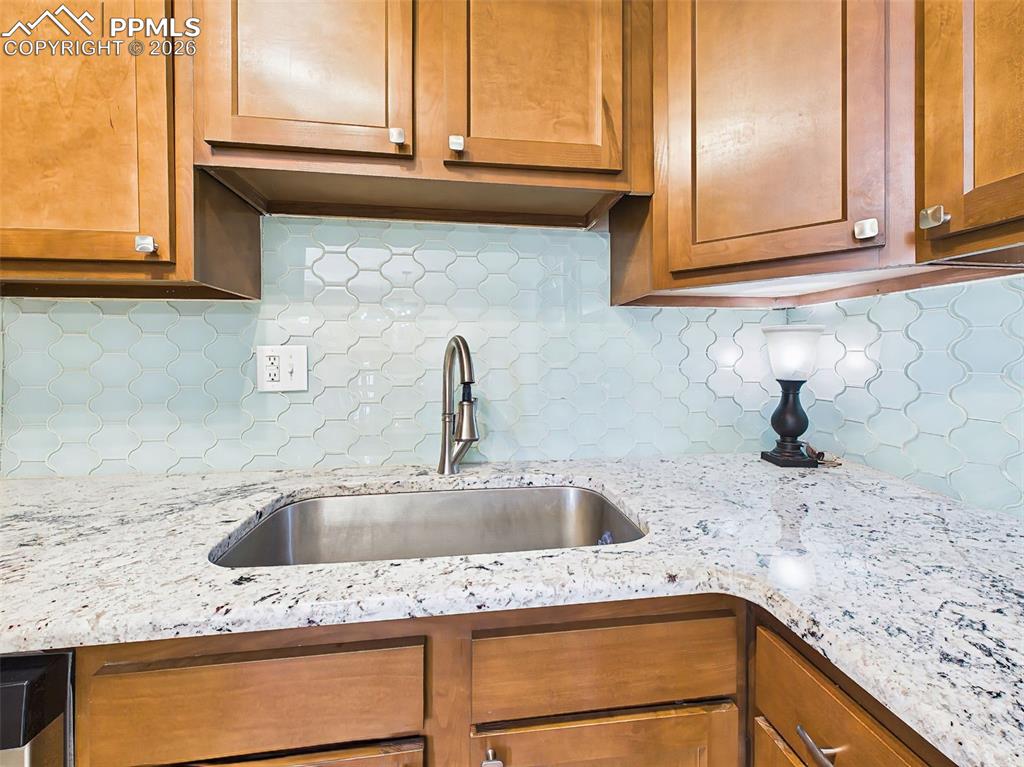 Image 13 of 50: Close-up of the granite countertops and designer backsplash, highlighting q