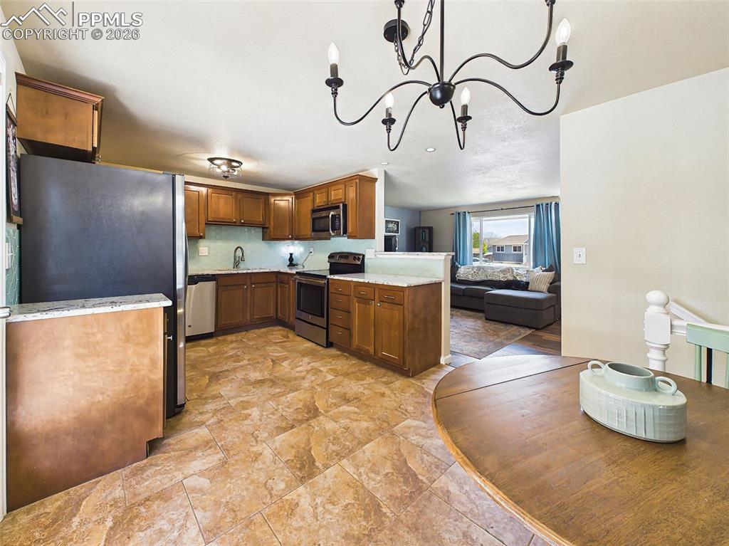 Image 15 of 50: Open-concept kitchen that flows into the living area, complete with a break