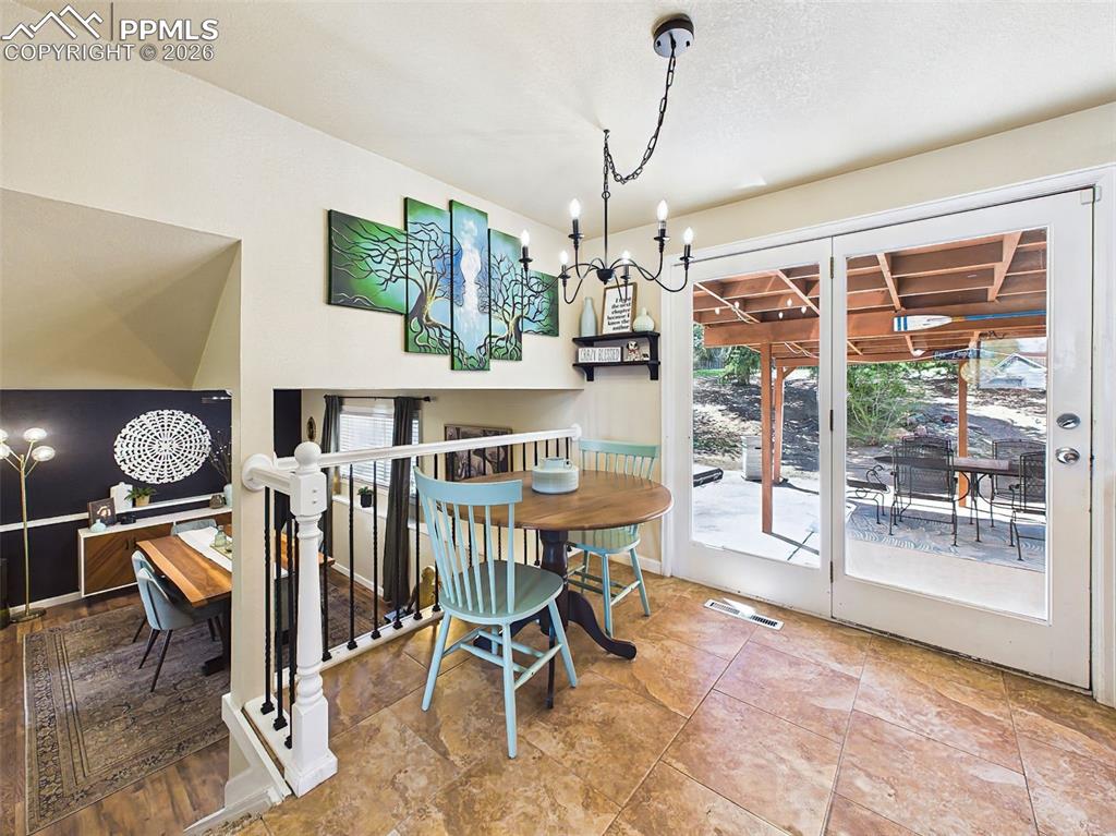 Image 17 of 50: Charming breakfast nook with a stylish chandelier and direct access to the 