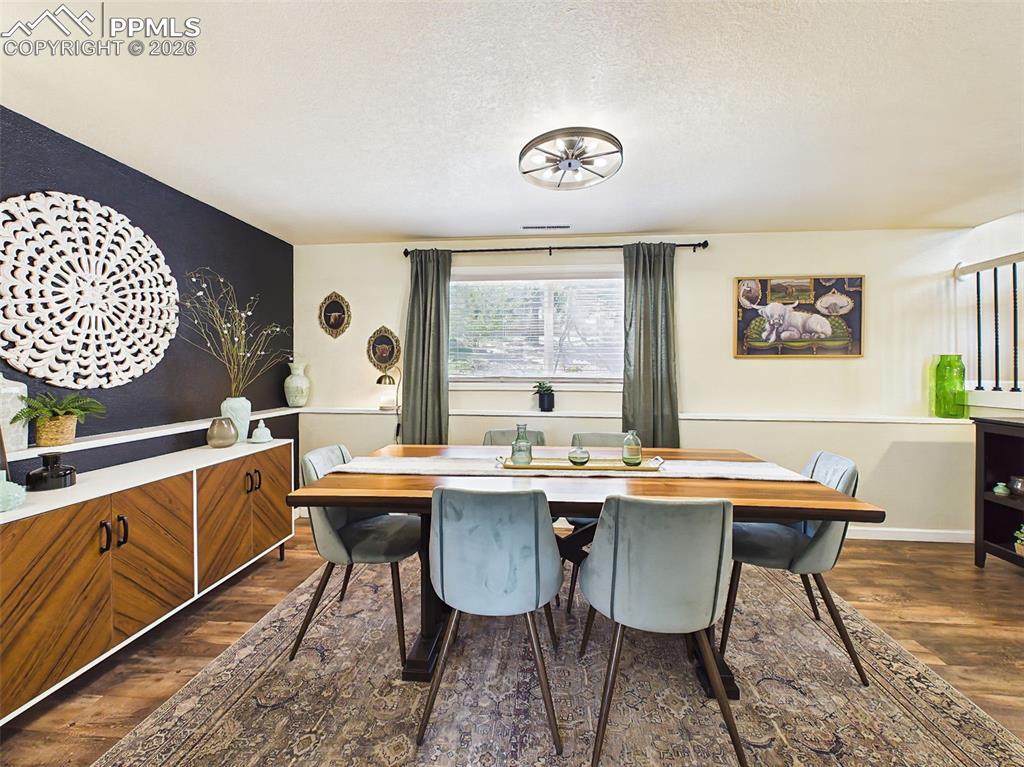 Image 21 of 50: Elegant dining area with a statement accent wall, modern lighting, and plen