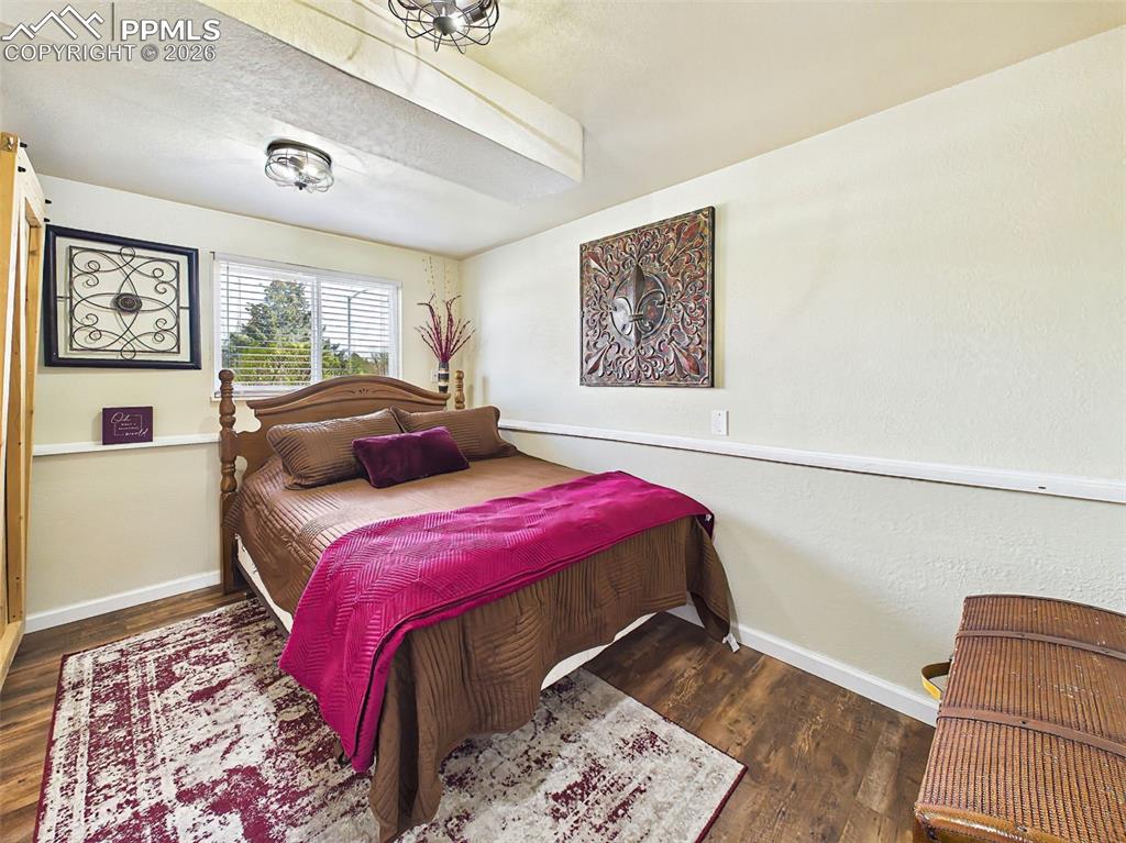 Image 22 of 50: Cozy bedroom with wood-style flooring, a large closet, and natural light fr