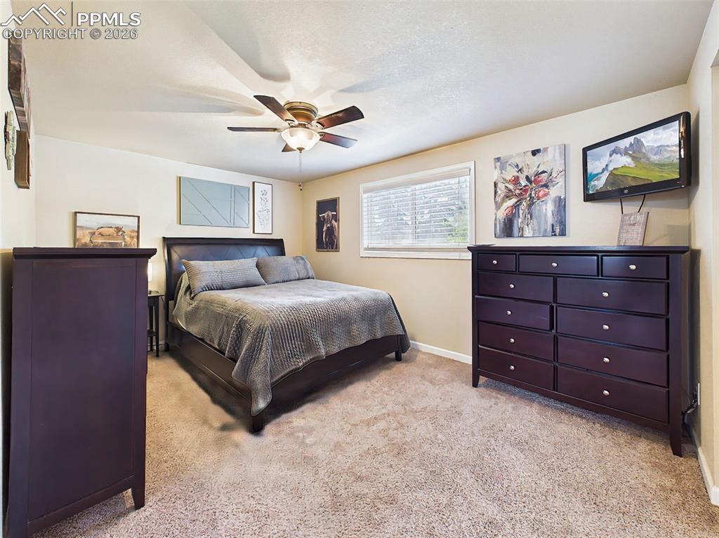 Image 26 of 50: Comfortable and well-sized bedroom featuring soft carpeting, neutral tones,