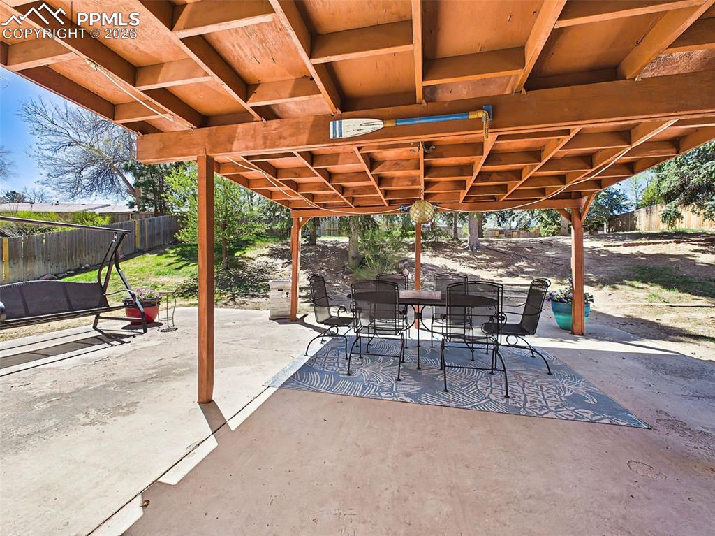 Image 38 of 50: Expansive covered patio with ample seating space, ideal for outdoor dining 