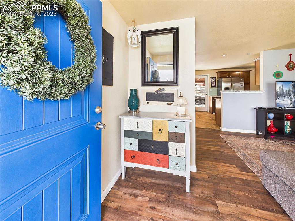 Image 4 of 50: Welcoming front entry with a bold accent door and decorative touches, setti