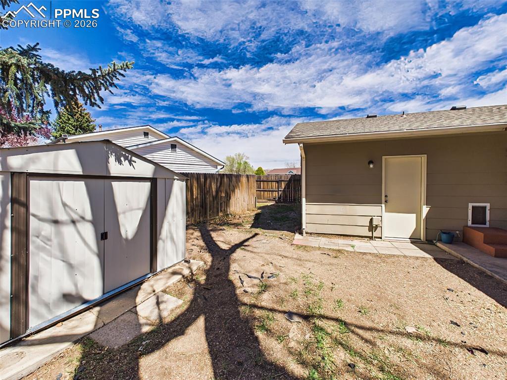 Image 41 of 50: Convenient side yard with storage shed and easy access to the backyard, ide