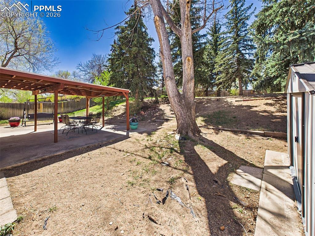 Image 43 of 50: View from the patio highlighting the large yard and surrounding trees, perf